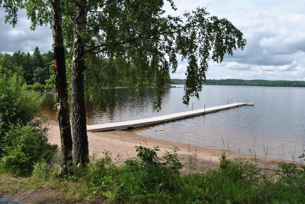 Badbrygga vi sjö. Sanstrand och björkskog