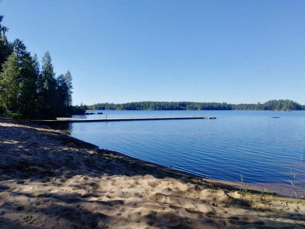 Badplats. Sandstrand med badbrygga.