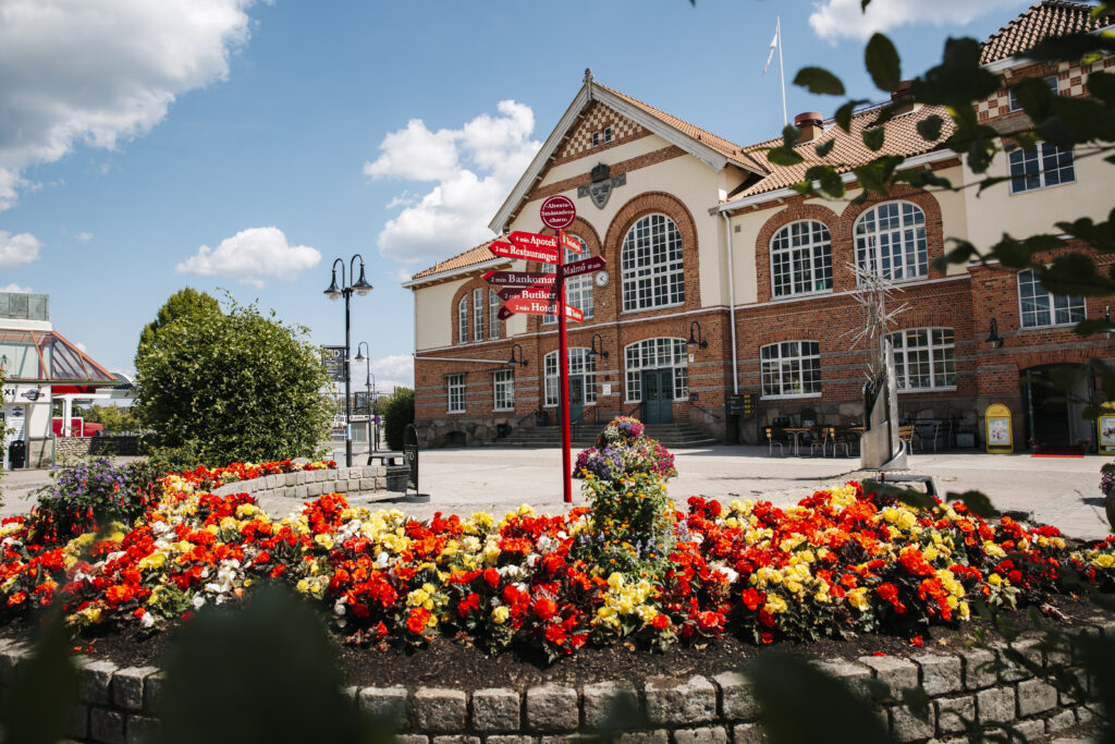 Alvesta stationshus. I förgrunden syns en plantering med blommor i rött och gult.