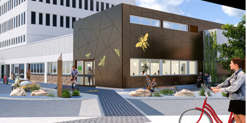 En skissbild av den nya entrén till kommunhuset. Fasaden i den vänstra delen är täckt med cortenplåt. På fasaden är fyra gula bin. 