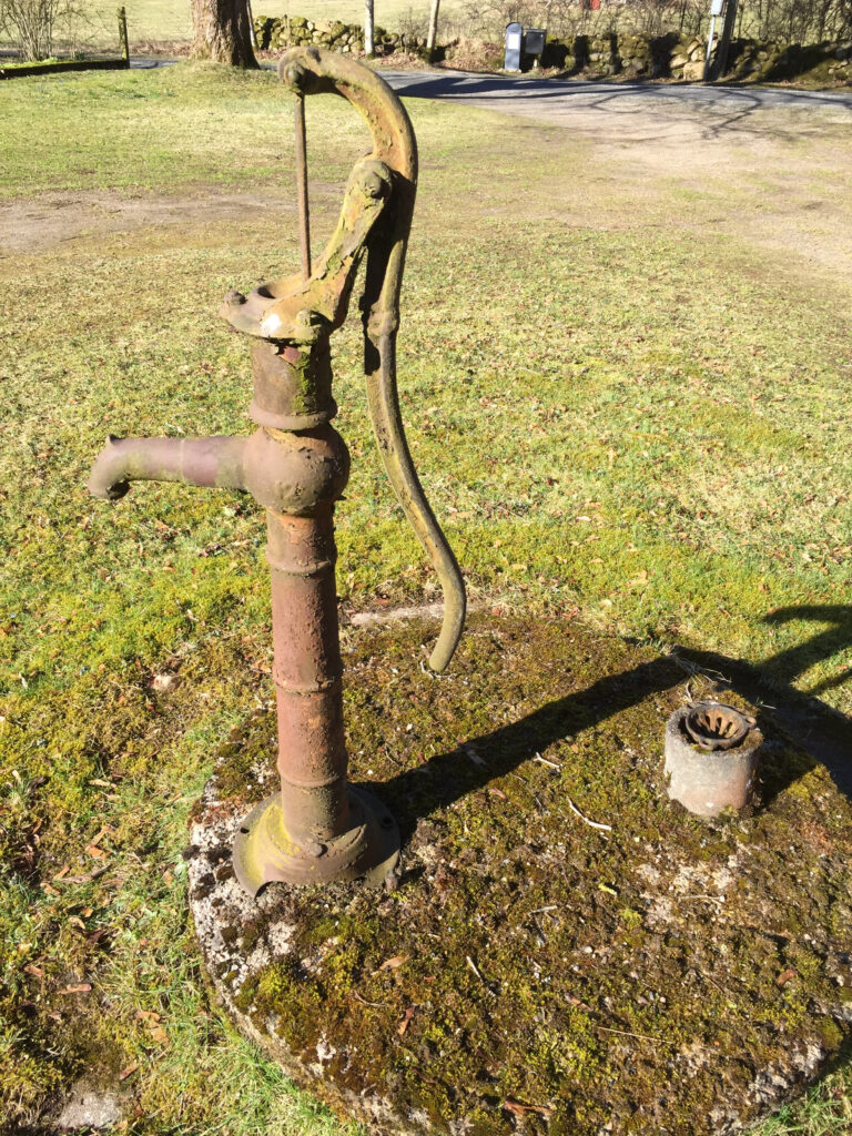 En grön pump som står på en gräsyta
