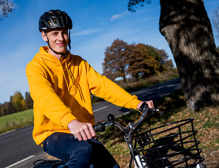 En cyklande man med gul jacka och cykelhjälm