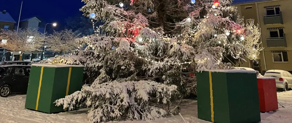Gran täkt med snö och med stora paket under