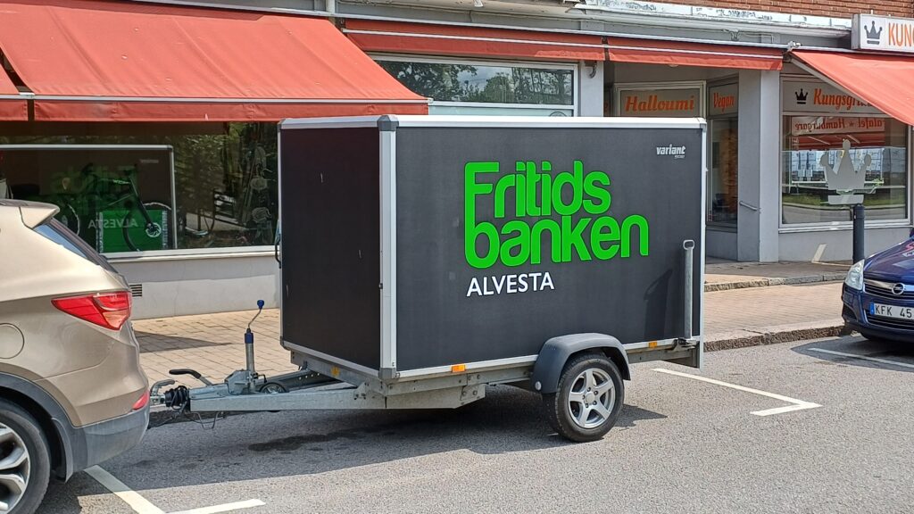Ett svart lastsläp med texten "Fritidsbanken Alvesta"