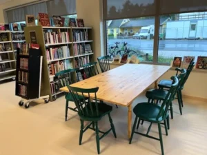 Ett bibliotek med bord, stolar och bokhyllor.