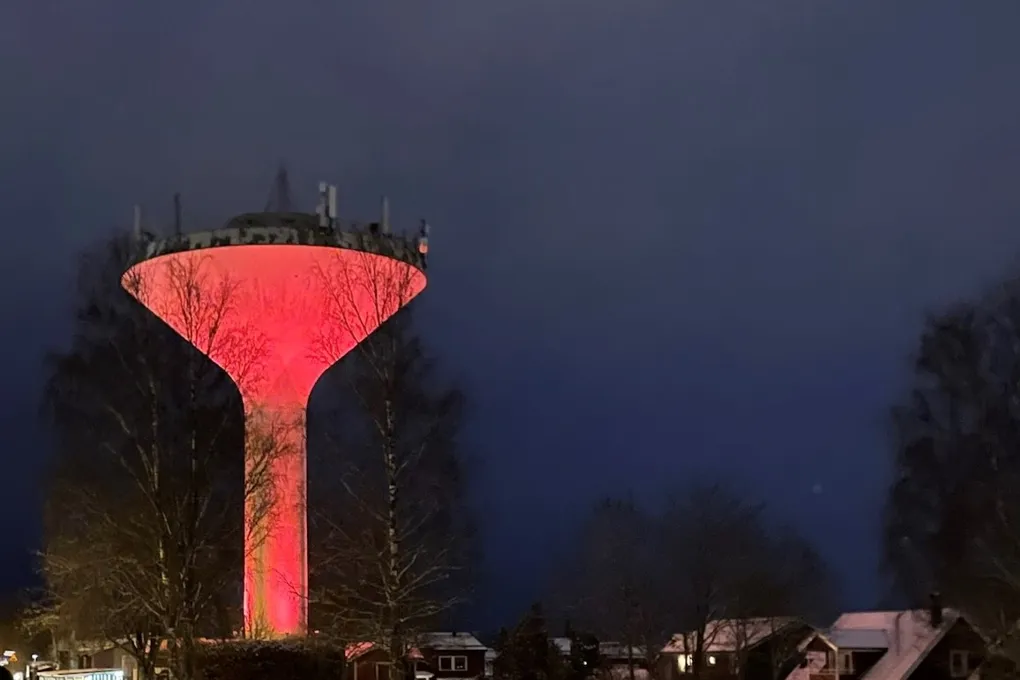 Ett svampformat vattentorn upplyst i orange