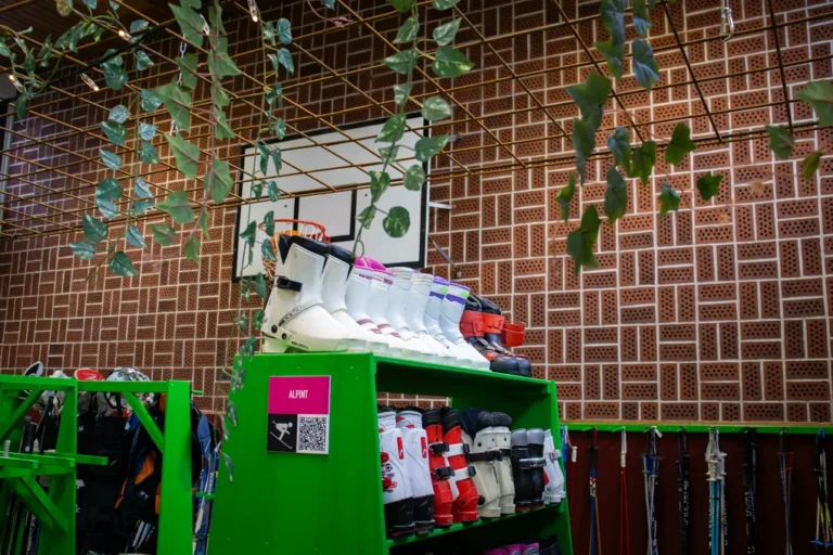 En grön hylla fylld med massor av alpintpjäxor.