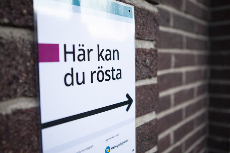 Närbild på affisch utanför vallokal där det står:" Här kan du rösta".