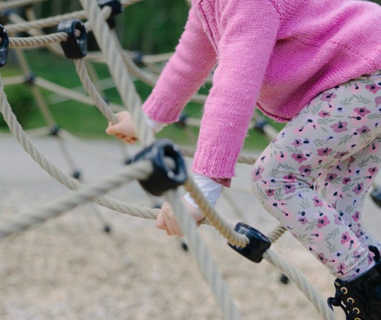 Barn klättrar i lekpark.