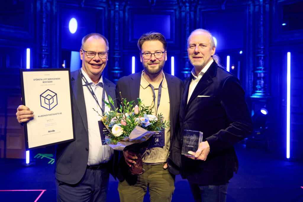 Tre personer som håller i diplom och en blombukett