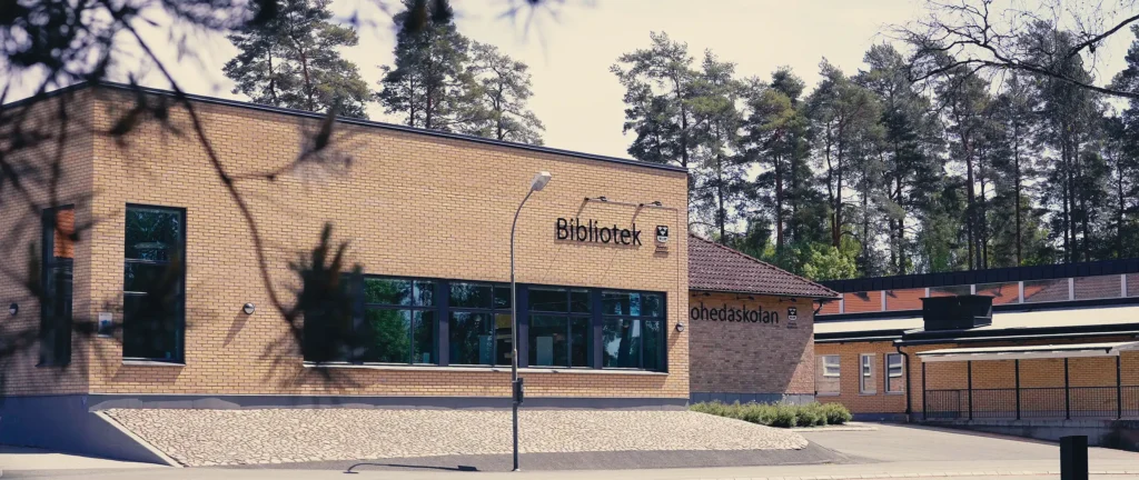 En tegelbyggnad med en parkeringsplats framför sig.