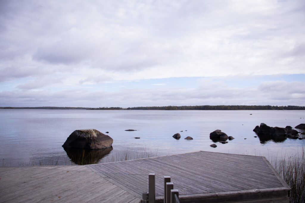 En träbrygga som ligger intill en stor vattensamling.