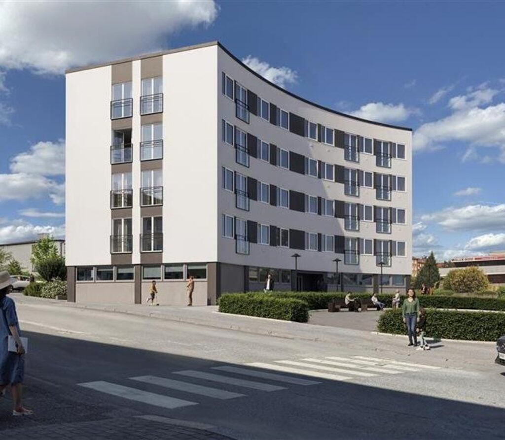 ett vitt lägenhetshus med grå detaljer