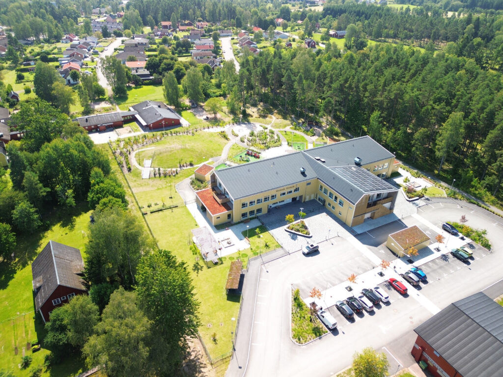 En flygbild av en stor byggnad omgiven av träd.