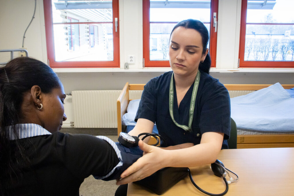 En kvinna kontrollerar en annan kvinnas blodtryck.