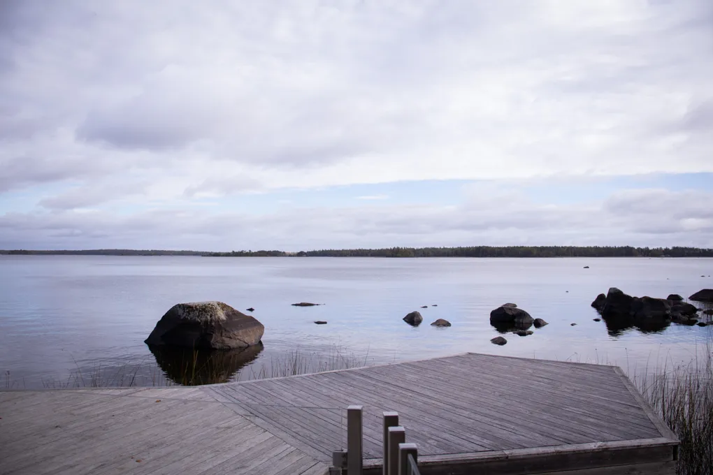 En träbrygga som ligger intill en stor sjö.