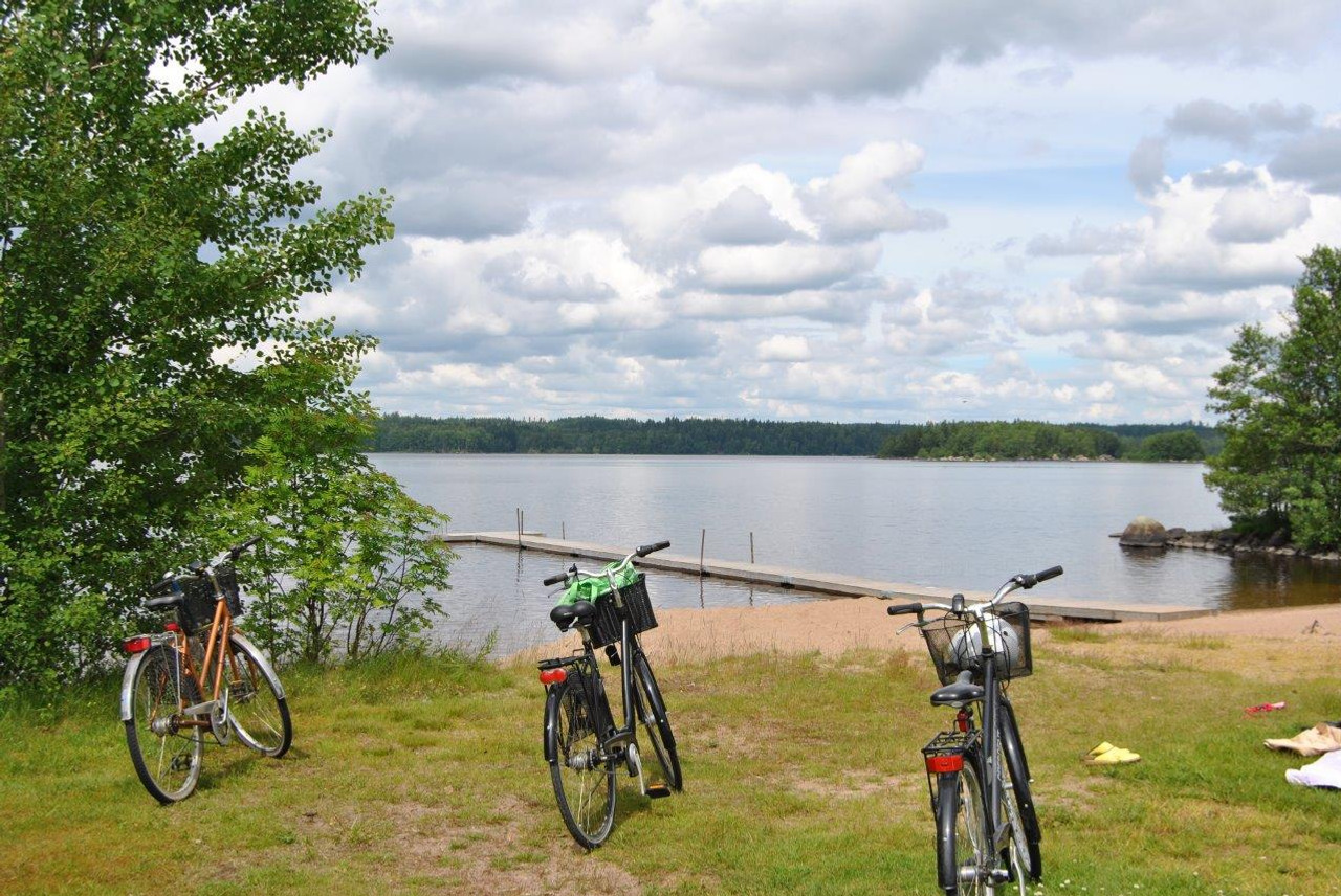 Några cyklar parkerade intill en sjö.