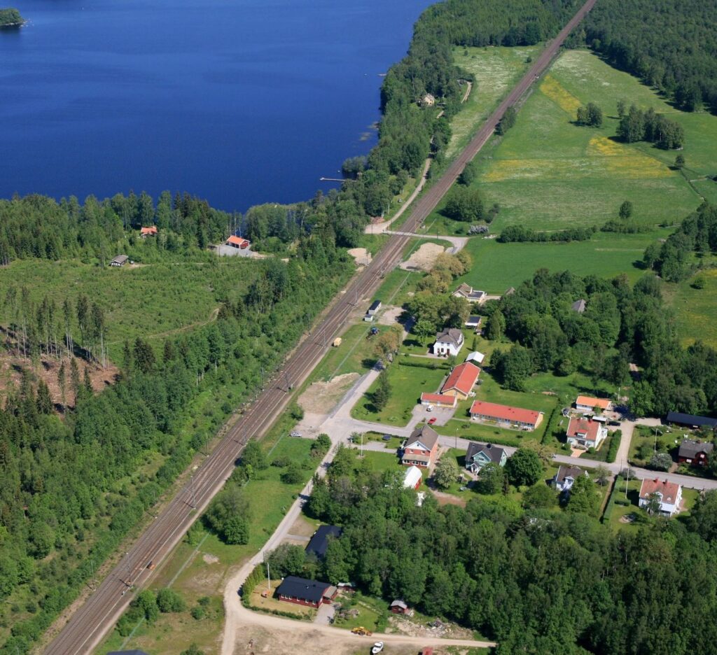 Flygbild över tomtområde där sjö syns