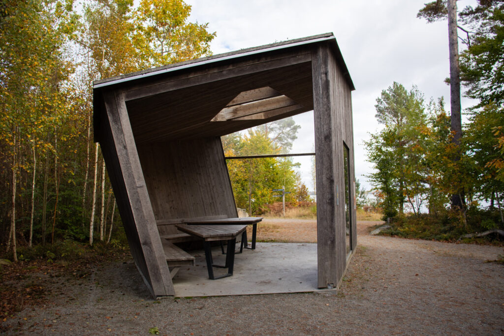 En träbyggnad med ett picknickbord i.