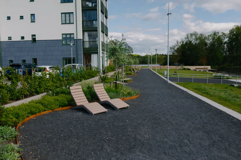 Några trädgårdsstolar som sitter på toppen av en grusväg.
