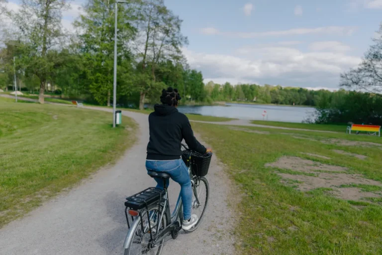 En kvinna som cyklar längs en grusväg.