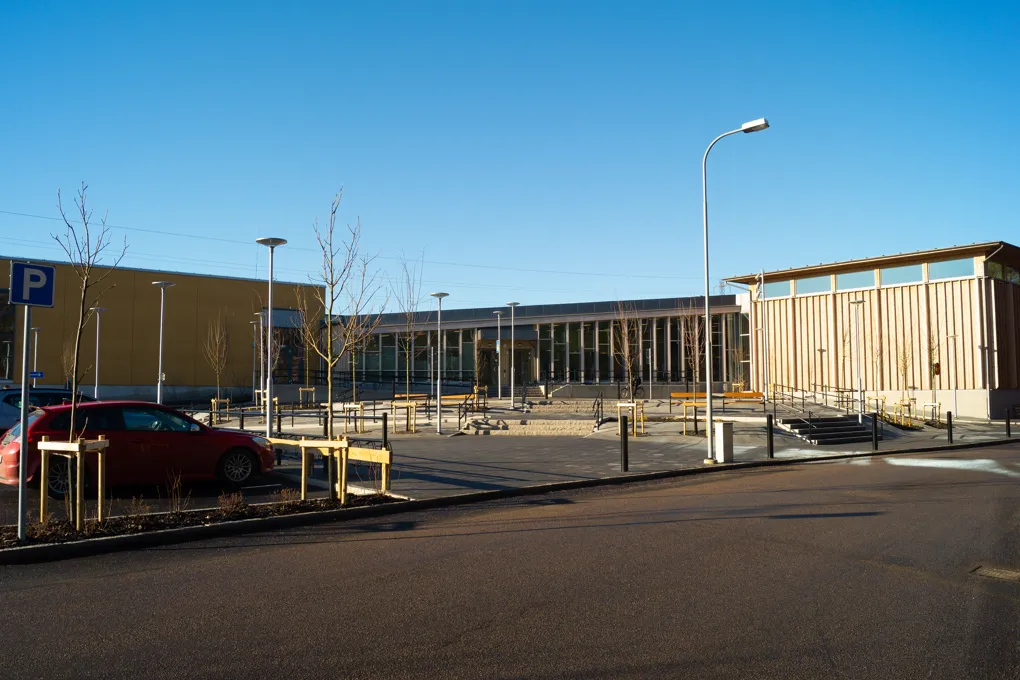 En bil som står parkerad på en parkeringsplats bredvid en byggnad.